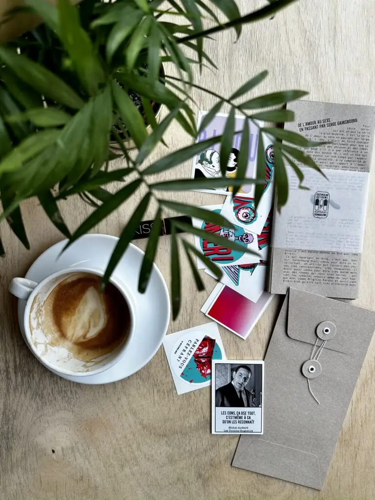 naklejki francuskie na stole z kawą i kwiatem, koperta vintage rozmycie